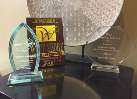 Several awards that PartnerShip has won are sitting on a table.